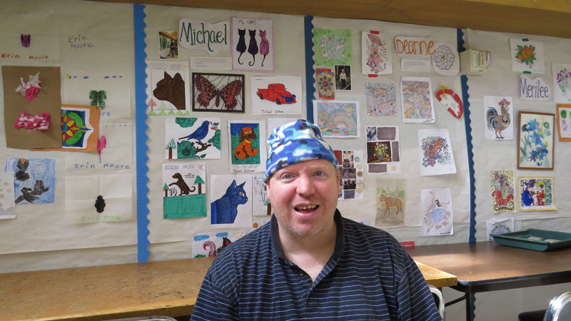 Smiling Patient in front of art projects